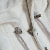 The sides and front opening of the Hood of the WeatherWool Anorak are adjusted by means of laces and cord locks.  The laces are made of the same 100% WeatherWool Certified Fine Wool Fiber as the rest of the garment.   A separate adjustment from the read of the Hood control how far forward or back the Hood sits on the head.